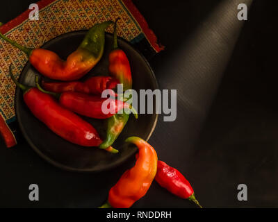 Ciotola di peperoncino rosso su sfondo nero Dark Fotografia Foto Stock