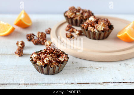 Popcorn al cioccolato in cottura rustico stampi su un tavolo di legno Foto Stock