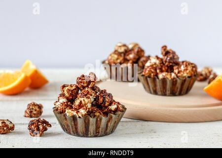 Popcorn al cioccolato in cottura rustico stampi su un tavolo di legno Foto Stock