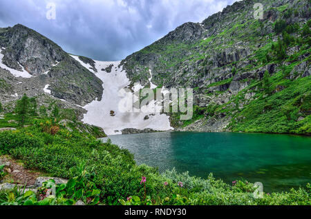 Uno da sette più pulito di montagna laghi Karakol, situato nella valle ai piedi del Bagatash pass, montagne di Altai, Russia. Coperte di neve o pendenza Foto Stock