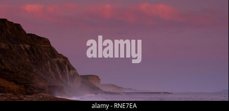 Eype, Dorset, Regno Unito. 18 febbraio 2019. Tempo nel Regno Unito: Il cielo si illumina di rosa sulle lontane scogliere di West Bay al tramonto. Credit: Notizie dal vivo di DWR/Alamy Foto Stock