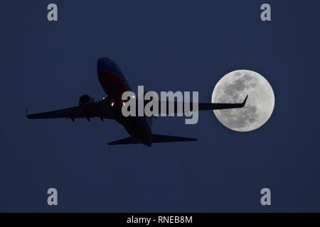 Phoenix, Arizona, Stati Uniti. 18 Febbraio, 2019. Febbraio 18, 2018 - Phoenix, Arizona, Stati Uniti d'America - un Southwest Airlines 737 decolla da Phoenix Sky Harbor International Airpor come un super luna sorge nella distanza. Credito: KC Alfred/ZUMA filo/Alamy Live News Foto Stock