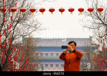 (190219) -- PECHINO, febbraio 19, 2019 (Xinhua) -- Un uomo prende le foto di lanterne coperte da neve lungo il Qianmen street a Pechino Capitale della Cina, febbraio 19, 2019, in occasione della lanterna cinese Festival. (Xinhua/Shen Bohan) Foto Stock