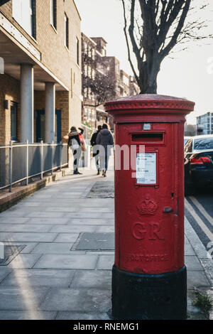 London, Regno Unito - 3 Febbraio 2019: Rosso postbox appartenente alla Royal Mail su una strada di Londra. Royal Mail è un servizio postale e di corriere espresso in sede di Nazioni Unite Foto Stock