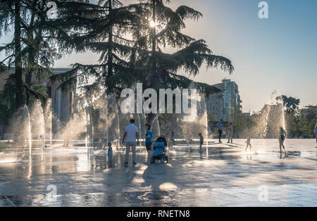 Giovani famiglie con bambini in Piazza Skanderbeg nella parte anteriore delle fontane, Tirana, Albania Foto Stock