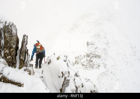 Alpinista sul bordo di estensione, Helvellyn, in condizioni invernali, Parco Nazionale del Distretto dei Laghi, Cumbria, Regno Unito. Foto Stock