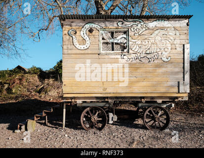 Il lato di un vecchio e abbandonato gypsy caravan con un drago dipinto sul lato di essa, sulle rive di Loch Ness, Scozia Foto Stock