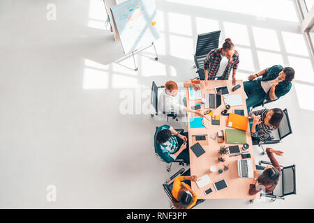 Multietnica gruppo diversificato di attività collaboratori nella riunione del team discussione, vista dall'alto ufficio moderno con spazio di copia. Partenariato per il lavoro di squadra professionale Foto Stock