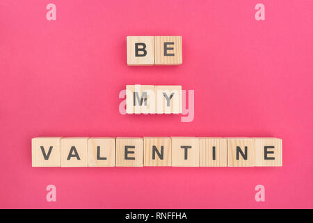 Vista dall'alto di essere il mio valentine lettering disposti dei cubi di legno su sfondo rosa Foto Stock