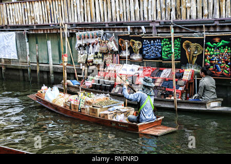 Bangkok in Thailandia - Dicembre 2016: barche sul canal vendono frutti, alimenti per i turisti nel Mercato Galleggiante di Damnoen Saduak. Foto Stock