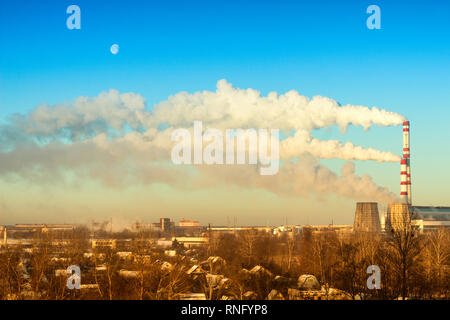 Due tubi di fumo all'la potenza termica impianto contro il blu del cielo il pupazzo di neve in inverno, la luna, sistema di alimentazione Foto Stock