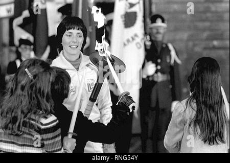 Primo Olympic torchbearer Sandy Norris, dopo il suo relè, sorge a attenzione a fiamma la cerimonia di arrivo. La fiamma, prima innescata in Olympia, Grecia, è portato in una serie di 52 torchbearers in un 1,000-mile relay dalla base a Lake Placid, N.Y., per aprire la XIII edizione dei Giochi Olimpici Invernali. Foto Stock