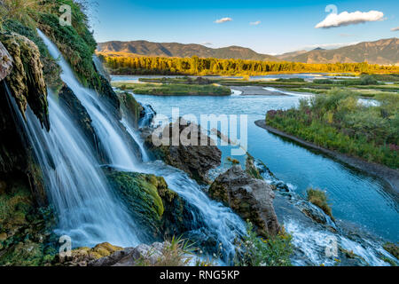 In autunno gli alberi della linea Snake River dove una piccola caduta di acqua fluisce Foto Stock