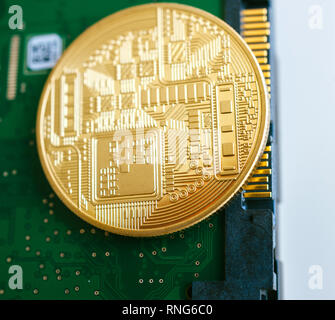 LONDON, Regno Unito - giu 30, 2014: Macro dettaglio di golden bitcoin su HDD hard disk drive SATA di connessione 6 Foto Stock