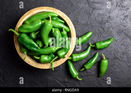 Verde jalapeno hot pepper nel piatto in legno closeup. Fotografia di cibo Foto Stock