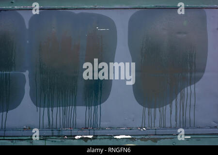 Una chiusa rimorchio grigio in lamiera di metallo e uno stallo per ventola merchandise forme umida stampe finestra sull'otturatore in condizioni di tempo piovoso. Foto Stock