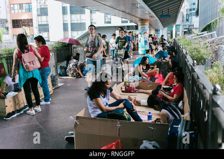 Filipiino lavoratori domestici sulla loro giornata di lavoro (domenica) raccogliere per divertimento e battute nelle strade di Honkong Foto Stock