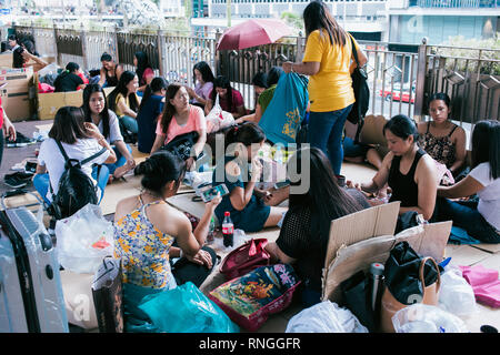 Filipiino lavoratori domestici sulla loro giornata di lavoro (domenica) raccogliere per divertimento e battute nelle strade di Honkong Foto Stock