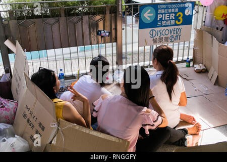 Filipiino lavoratori domestici sulla loro giornata di lavoro (domenica) raccogliere per divertimento e battute nelle strade di Honkong Foto Stock