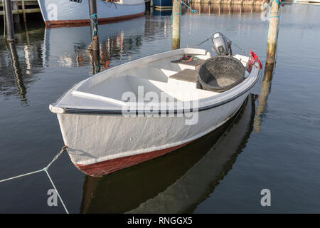 Di piccole dimensioni e di colore bianco in vetroresina barca da pesca con motore fuoribordo, ormeggiata in porto; Oester Hurup, Danimarca Foto Stock