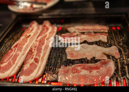 Korean barbecue in stile con juicy crudo marinato pancetta di maiale carne sulla stufa calda piastra. Foto Stock