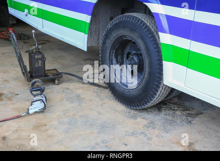 Bus di gomma della ruota in attesa di riparazione nel garage Foto Stock