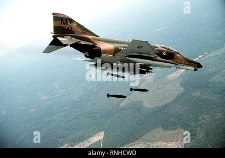 1980 - un'aria-aria - Vista laterale destra di una F-4E Phantom II aeromobile scenda sei Mark 82 500-pound low-trascinare le bombe su un intervallo. Il velivolo è portante ausiliaria di un serbatoio del carburante su ciascuna ala Foto Stock