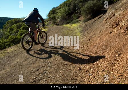 Un giovane corse la sua mountain bike in salita lungo una delle strade di fuoco in cascata Canyon Spazio aperto conservare. Foto Stock