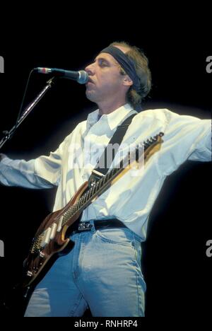 Mark Knopfler dei Dire Straits è mostrato esibirsi sul palco durante un concerto aspetto. Foto Stock