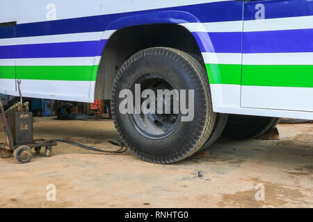 Bus di gomma della ruota in attesa di riparazione nel garage Foto Stock