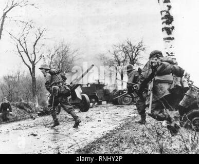 Truppe tedesche avanzare oltre abbandonate attrezzature americane - Panzergrenadier-SS Kampfgruppe Hansen in azione durante gli scontri in Poteau contro Task Force Myers, 18 dicembre 1944. Foto Stock