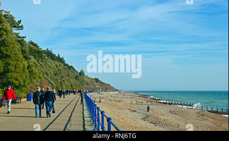 La gente camminare lungo la passeggiata a Eastbourne, East Sussex, Regno Unito. Sole brillante porta la gente fuori per il lungomare in febbraio. Foto Stock