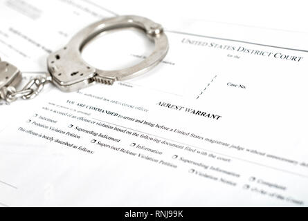 La corte distrettuale Mandato Court papers con le manette isolato su bianco con profondità di campo Foto Stock