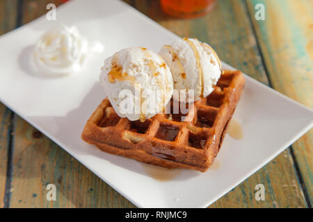 Due mestoli di vaniglia e caramello gelato Gelato waffle Foto Stock