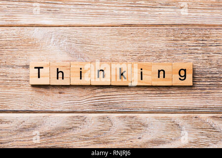 Pensando parola scritta sul blocco di legno. Pensando testo sul tavolo in legno per il desing, concetto. Foto Stock