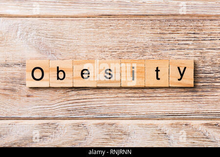 Obesità parola scritta sul blocco di legno. Obesità testo sul tavolo in legno per il desing, concetto. Foto Stock