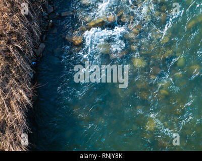 Splendido contrasto luminoso paesaggio di montagna. Il fiume di montagna scorre veloce attraverso le rocce della montagna, formando cascate e un sacco di spray. Foto Stock