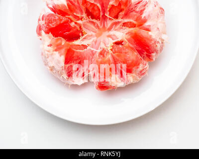 Pompelmo nella piastra isolata su sfondo bianco. Round di frutta fresca. Con il tracciato di ritaglio Foto Stock