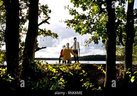 Famiglia su un pontone galleggiante sul lago ' Lac de la Mare ' in Goriaux, nella foresta demaniale di Raismes-Saint-Amand-Wallers, riserva naturale nelle scarpe- Foto Stock