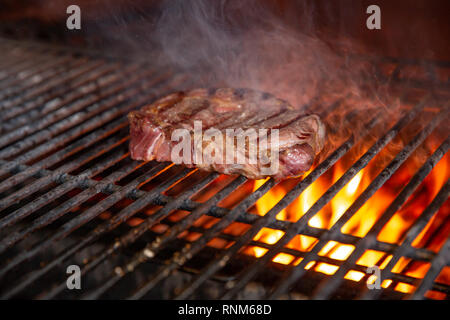 Un top controfiletto bistecca arrostito alla fiamma su un barbecue, una profondità di campo ridotta. Foto Stock