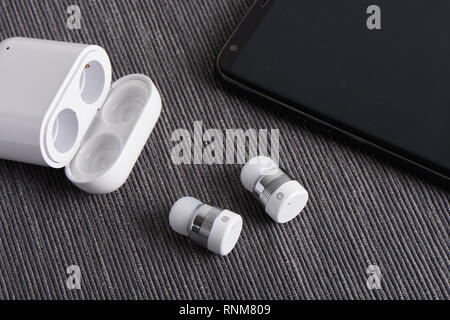 Wireless bluetooth cordless auricolari con custodia a pagamento e lo smartphone Foto Stock