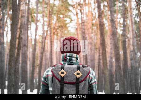 Escursionismo persona di sesso maschile in inverno foresta. Uomo in inverno a scacchi shirt passeggiate in splendidi boschi innevati Foto Stock