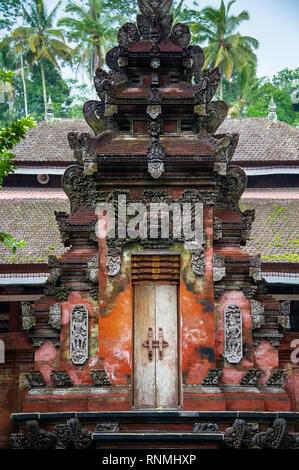 Il tradizionale design Balinese tempio indù edificio a Tirta Empul santo tempio dell'acqua, nei pressi di Ubud, Bali, Indonesia. Riccamente intagliato porta in Jeroan o inne Foto Stock