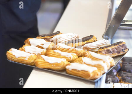 Vassoio di eclairs su pasticceria counter . Foto Stock