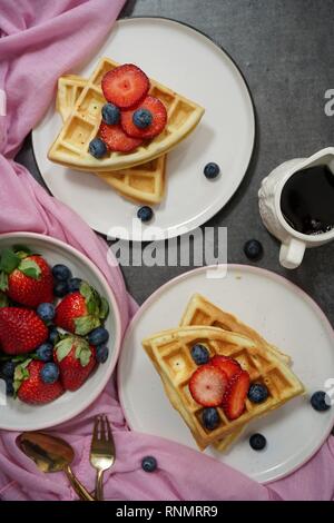 Waffles fatti in casa prima colazione con sciroppo di frutti di bosco vista aerea Foto Stock