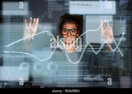 Giovane donna sta pensando di statistiche e grafici. Foto Stock