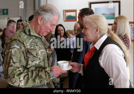 Il Principe di Galles, il colonnello, protezioni gallese è servito un drink da Maggie Cooper come egli incontra i membri della famiglia e del primo battaglione guardie gallese dopo il loro ritorno in Afghanistan, a Elizabeth caserma, Pirbright Camp a Woking. Foto Stock
