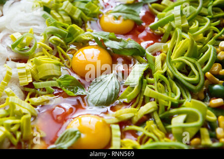 Pizza cruda con uova, porro, ketchup, la cipolla, il basilico e altri ingredienti Foto Stock