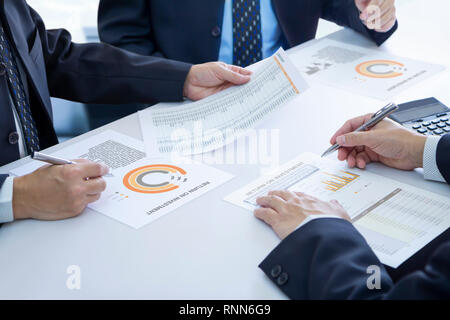 Gli imprenditori sono profondamente rivedendo un report finanziari per un ritorno sugli investimenti o di investimento analisi di rischio. Foto Stock