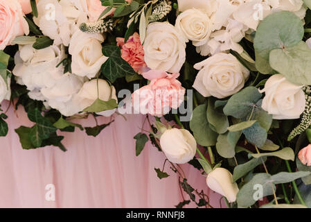 Si tratta di un sacco di fiori diversi su una tabella di nozze. La decorazione di un tavolo tessuto di colore rosa e in fiori freschi Foto Stock